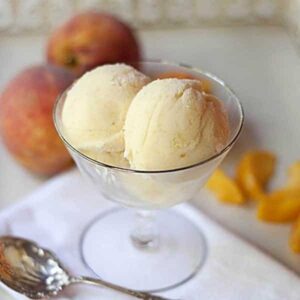 Creamy, cold and delicious homemade peach ice cream with sweet, fresh Georgia grown peaches and rich with eggs, heavy cream, and whole milk. https://www.lanascooking.com/homemade-peach-ice-cream