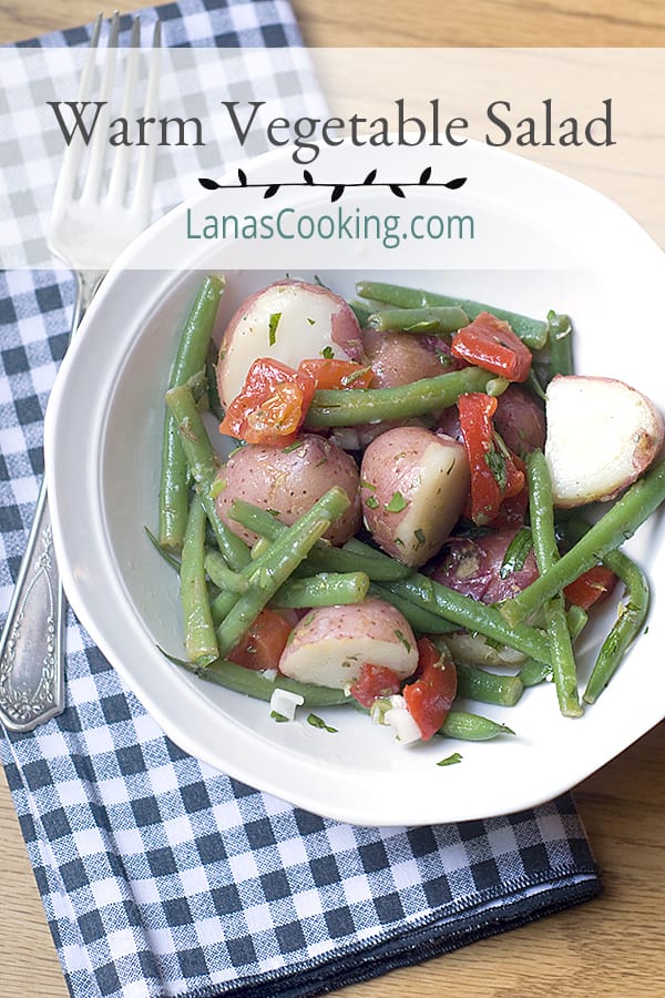 A delicious Warm Vegetable Salad with red skinned potatoes and green beans tossed in a tangy lemon-garlic dressing. Great year round side dish! https://www.lanascooking.com/warm-vegetable-salad/