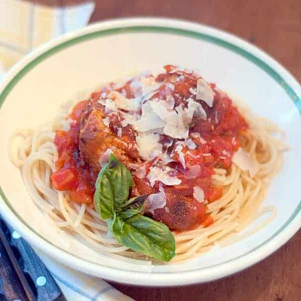 Baked Meatballs and Spaghetti served with tomato basil sauce. The meatballs are baked in the oven for a healthier alternative. https://www.lanascooking.com/baked-meatballs-and-spaghetti/