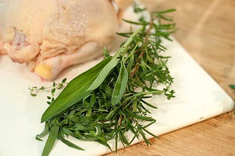 Cutting board with herbs for flavoring chicken