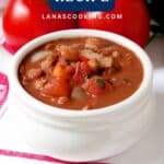 A white bowl of beans with tomatoes and onions, labeled Cowgirl Beans Recipe, on a red-striped towel.