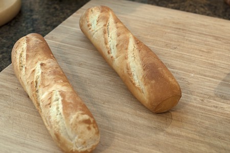 Baguettes for Mediterranean Tartine Two small baguettes on a cutting board.