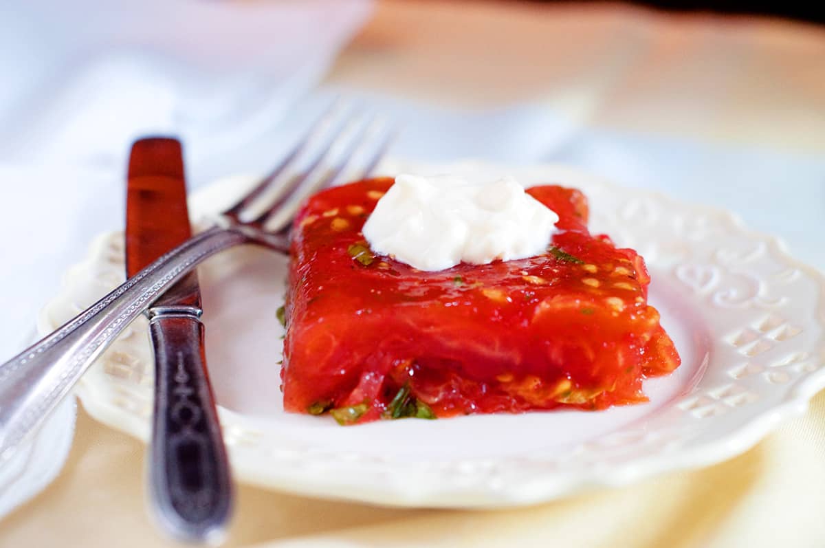 A serving of tomato aspic with a dollop of mayonnaise on top.