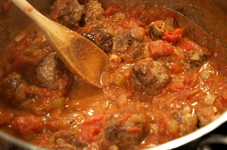 Meatballs cooking in tomato sauce.