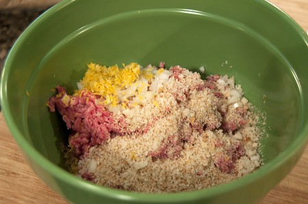 Ingredients for meatballs in a mixing bowl.