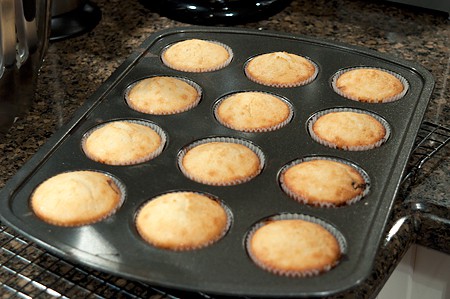 Golden brown muffins in a baking tin.