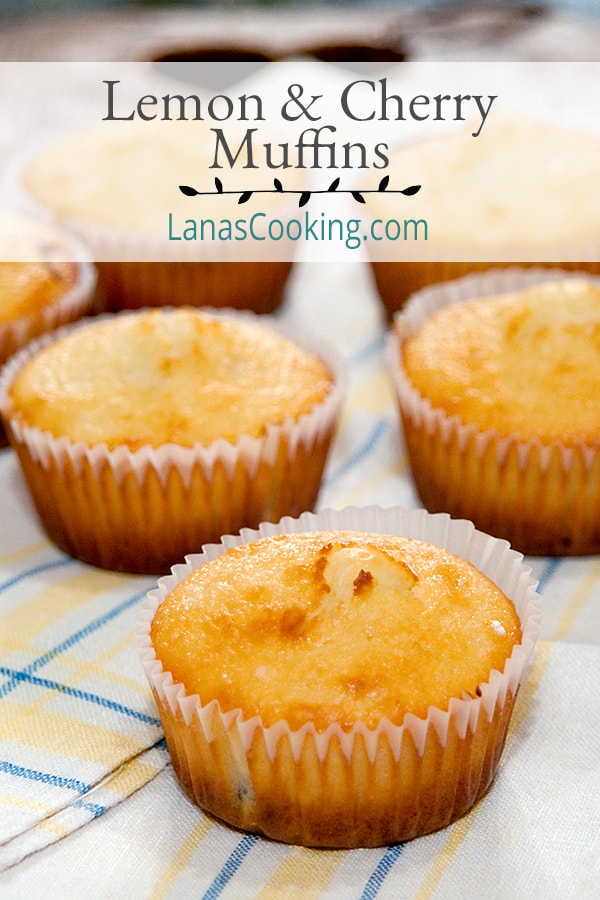 Golden brown lemon and cherry muffins on a decorative napkin.