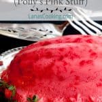 Raspberry jello mold on a silver serving tray with vintage serving pieces in the background. Text overlay for pinning.