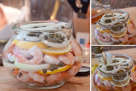 Shrimp and pickling ingredients layered in a glass jar.