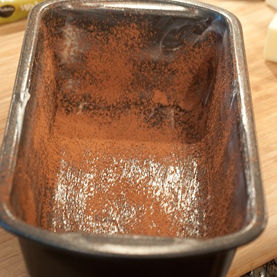 Loaf pan prepped with butter and cocoa powder.