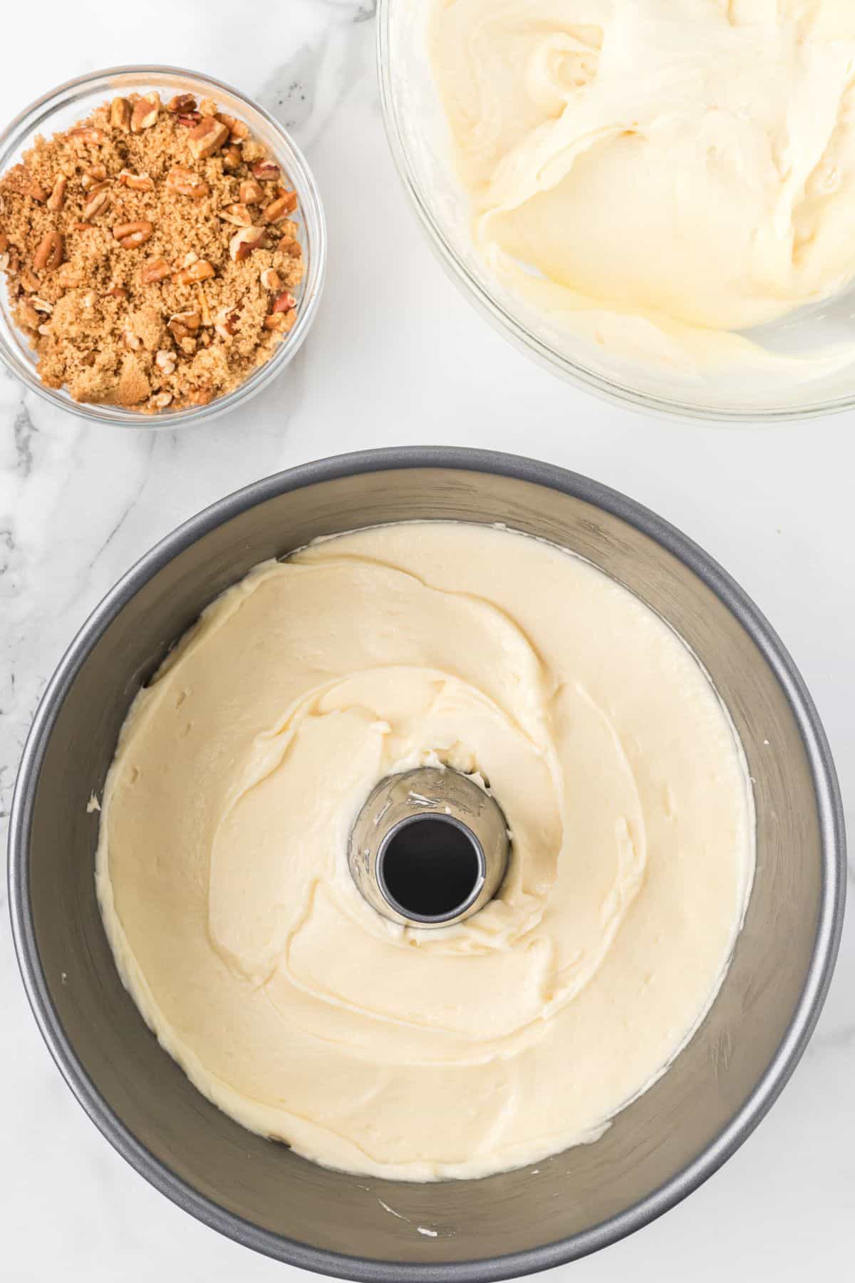 Half of the coffee cake batter spread into a prepared flute pan.