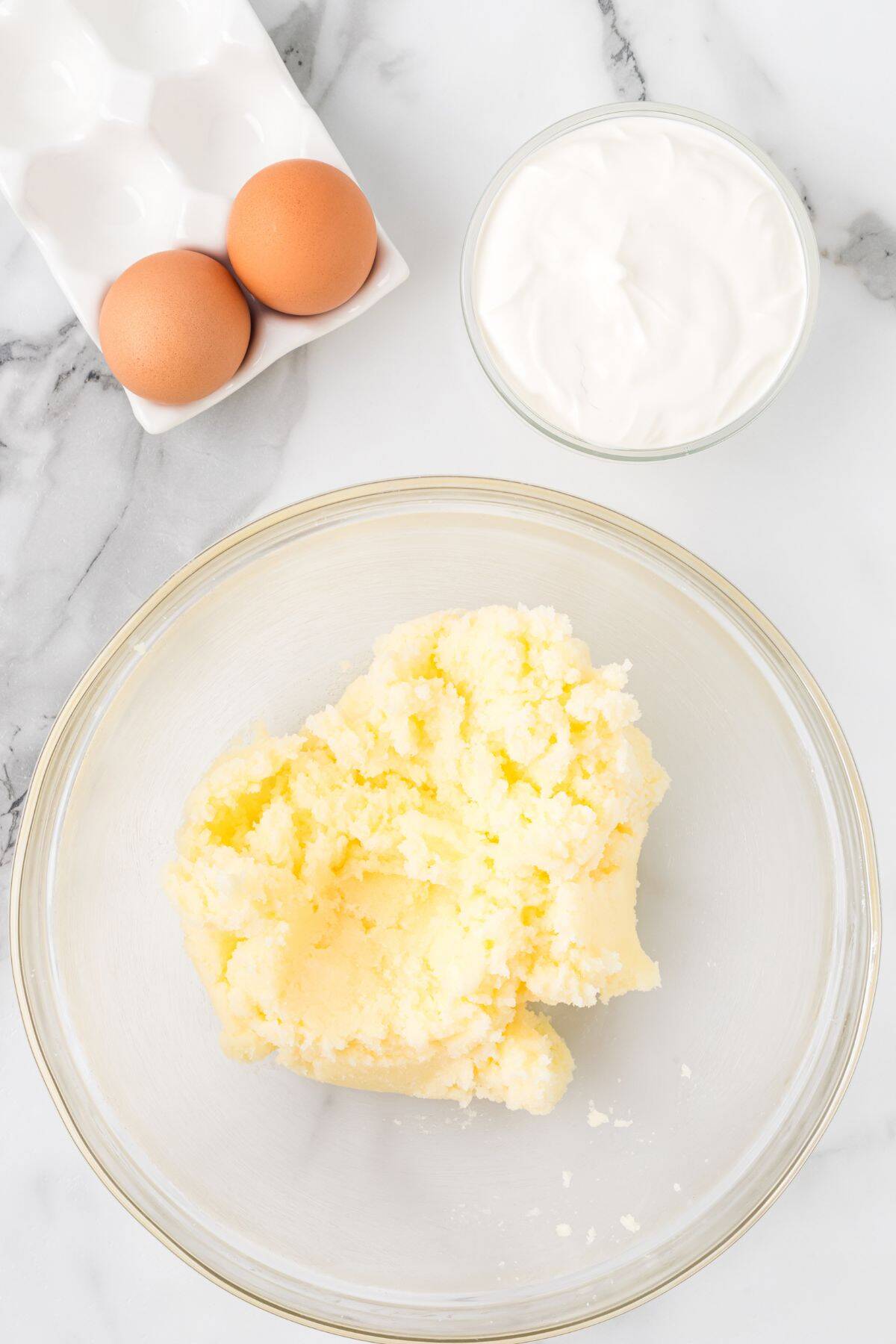 Butter after being creamed with the sugar in a glass bowl.