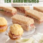 An assortment of tea sandwiches, including mini muffins with ham, rectangular roast beef finger sandwiches, and triangular cucumber sandwiches, arranged on a white tablecloth.
