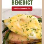 Eggs Benedict with asparagus and ham on toast, topped with hollandaise sauce and chopped chives.