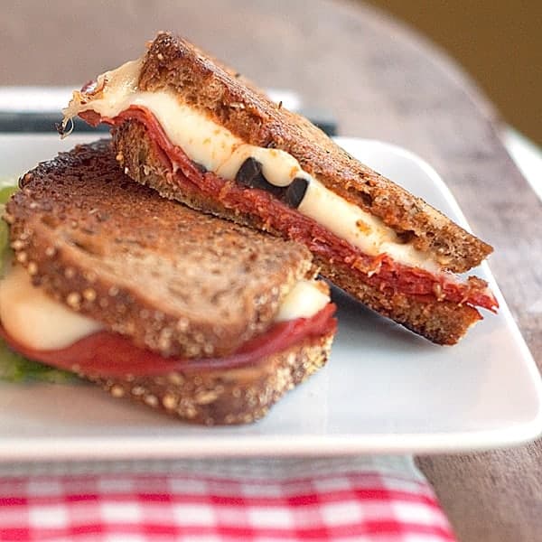 Pepperoni pizza grilled cheese on a white plate.