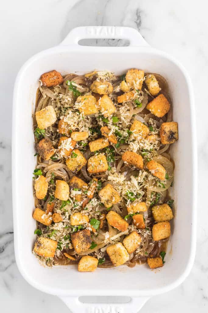 Croutons and cheese added to onions.