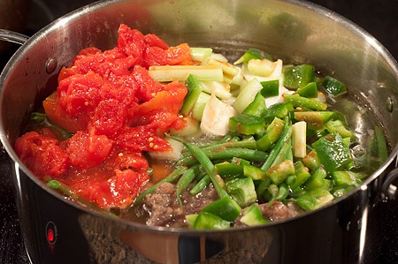 Add veggies to Creole Beef and Okra Soup Beans, celery, tomatoes, and bell pepper added to the soup pot.