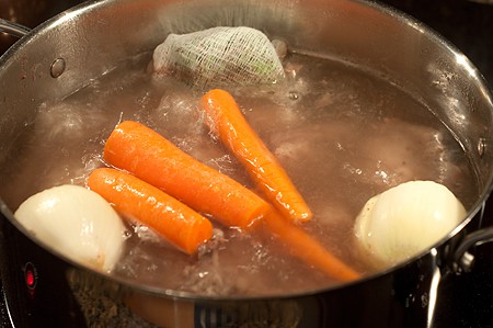 Aromatic carrots and onions added to the soup pot.