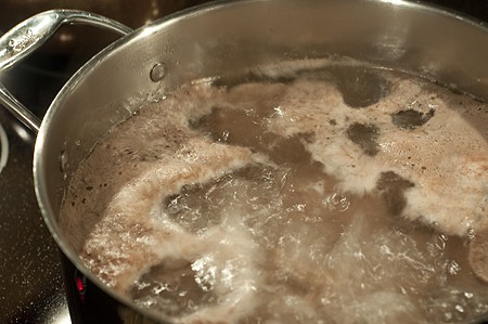 Beef short ribs cooking in a soup pot.