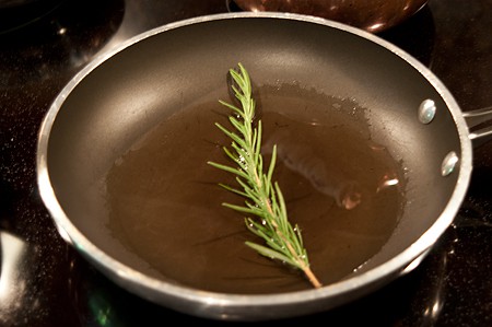 Rosemary and oil in a frying pan.