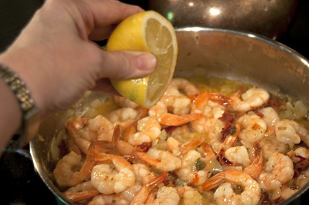 Adding lemon juice and pasta cooking water to the sauce.