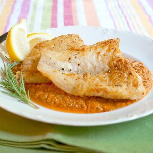 Pan Fried Fish with Red Pepper Sauce - an easy weeknight dinner of pan-fried fish served atop a sauce of roasted red peppers, tomatoes, and garlic. https://www.lanascooking.com/pan-fried-fish-with-red-pepper-sauce/