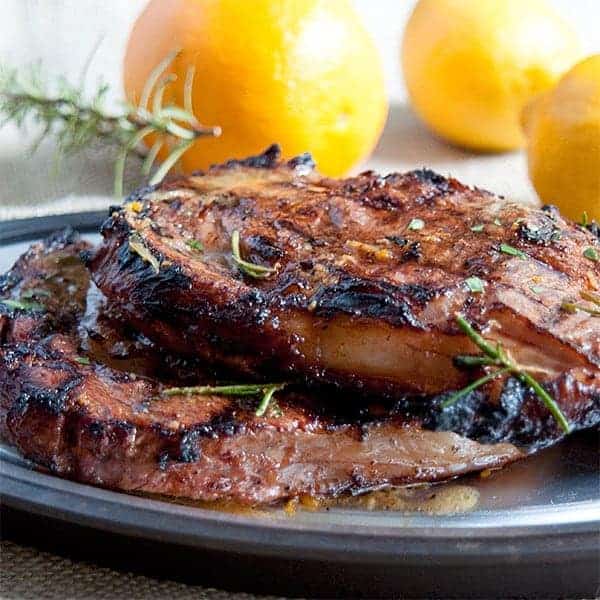 Two grilled steaks on a serving plate.