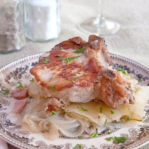 Pork Chops with Potatoes - a very old French recipe for slow cooked pork chops, onions, and potatoes. Melt in your mouth delicious! https://www.lanascooking.com/pork-chops-with-potatoes/