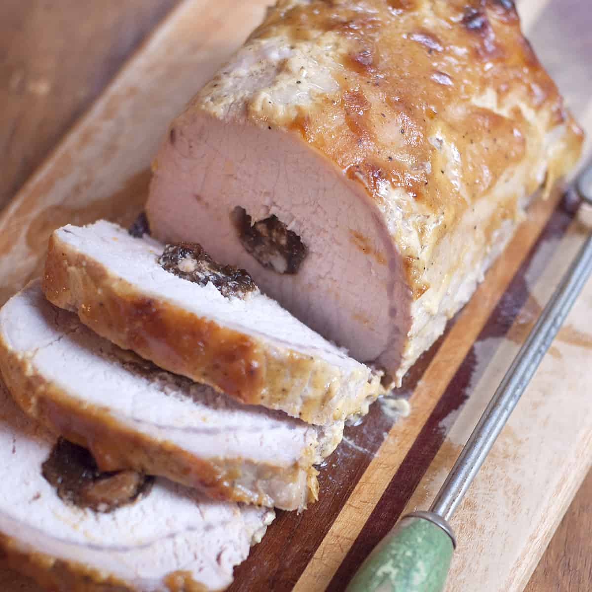 Sliced Apricot and Prune Stuffed Pork Loin on a serving tray.