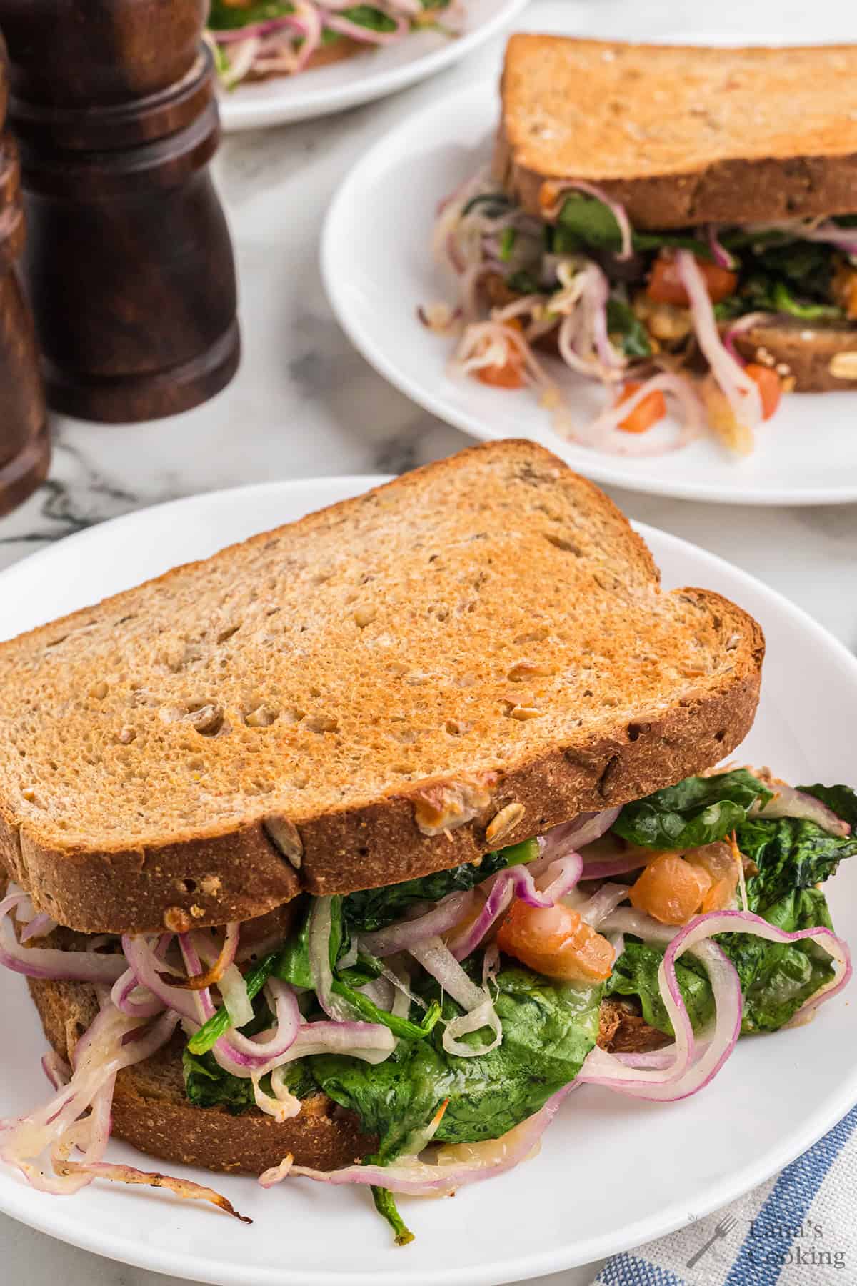 Finished sandwich on a white serving plate.