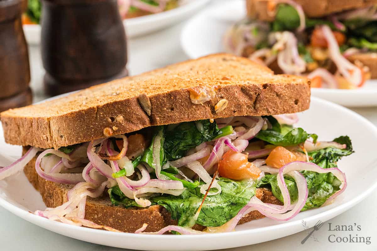 Finished sandwich on a white serving plate.