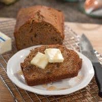 A slice of carrot pecan quick bread with butter and honey.
