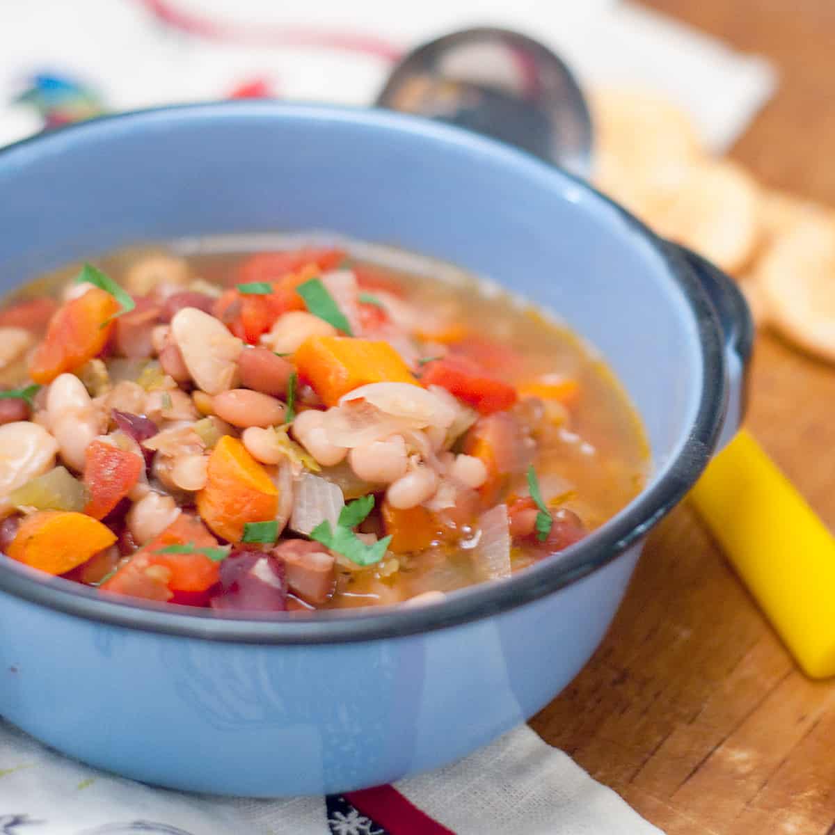 A bowl of mixed bean soup with a serving ladle alongside.