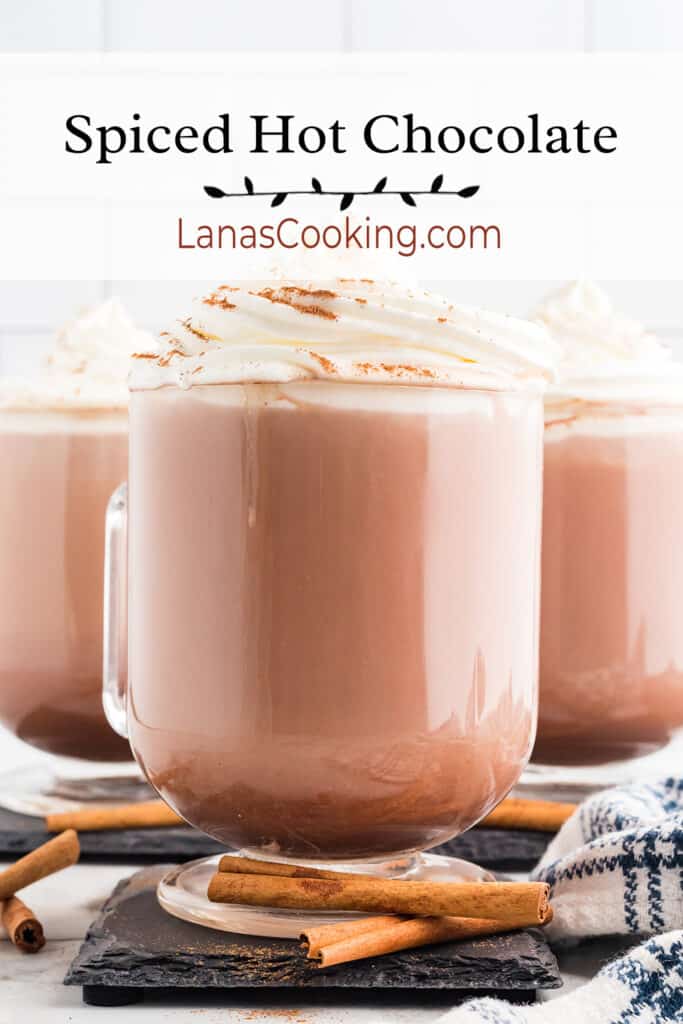 Three cups of hot chocolate with whipped cream and cinnamon on top.