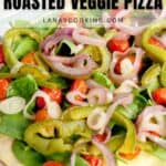 A roasted vegetable pizza topped with spinach, cherry tomatoes, sliced red onions, and green peppers on a white plate. Text on image reads, Quick & Easy Roasted Veggie Pizza.