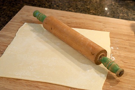 Puff pastry being rolled out on a cutting board