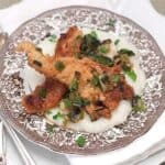 Chicken with Grits for a Cozy Winter Supper - Creamy, buttery grits topped with fried chicken strips and a green onion pan sauce. https://www.lanascooking.com/chicken-with-grits/