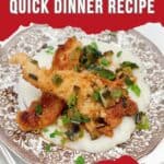A serving of chicken with grits on a decorative plate.