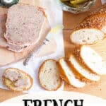 Sliced French country terrine on a serving board with sliced baguette, cornichons, and mustard.