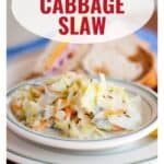 A plate of creamy hot cabbage slaw in front of a sandwich, with text reading Hot Cabbage Slaw.