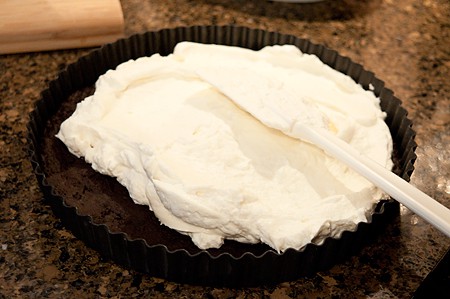 Adding the whipped cream and cream cheese layer to the crust.