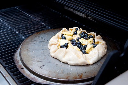 Pineapple Blueberry Basil Galette being baked on the grill.