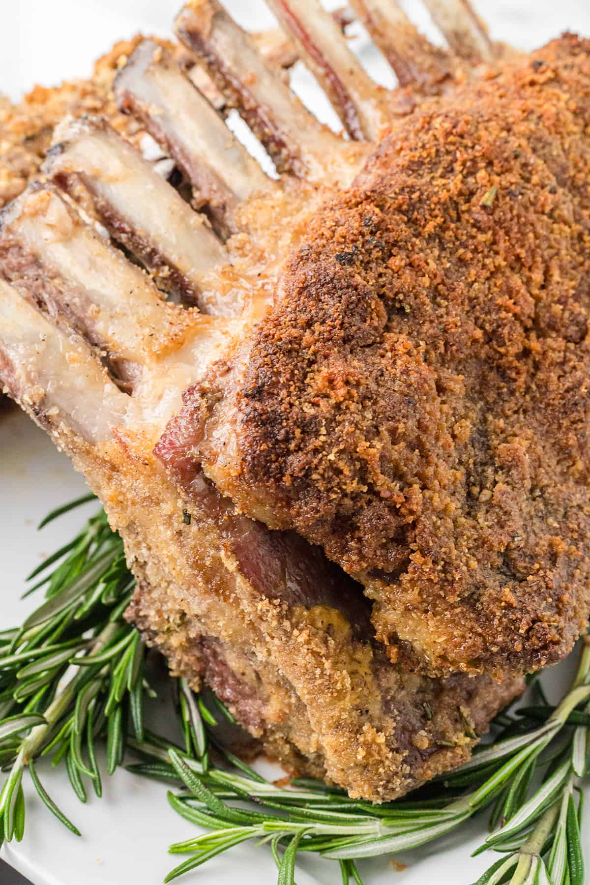 Finished racks of lamb on a serving plate.