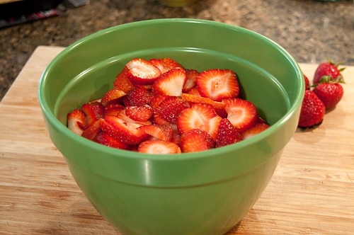 Sliced fresh strawberries in a mixing bowl.