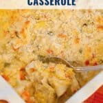 Baked chicken artichoke casserole in a dish, topped with breadcrumbs, with a spoon serving a portion.