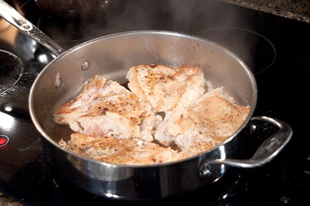 Cooking chicken breasts in a skillet.