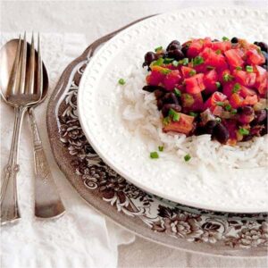 Black Beans and Rice with Ham - classic black beans and rice with the addition of tomatoes and ham. Garnished with fresh chopped tomatoes and chives. https://www.lanascooking.com/black-beans-and-rice-with-ham/