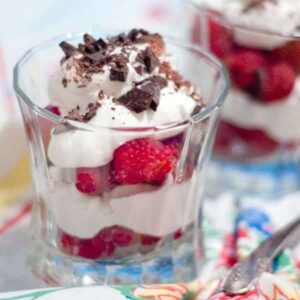 Layers of raspberries, whipped cream, and chocolate in a dish.
