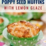 A poppy seed muffin with lemon glaze in a green heart-patterned paper liner sits on a floral napkin, with more muffins blurred in the background.