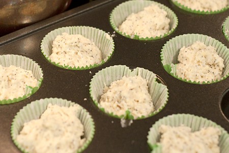 Paper muffin cups in a tin filled with batter.